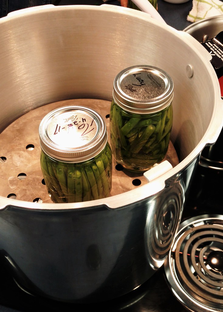 Glass jars being loaded into a pressure canner